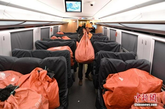 资料图：2019年11月11日，工作人员将成都发往南京的包裹装上列车。中新社记者 刘忠俊 摄